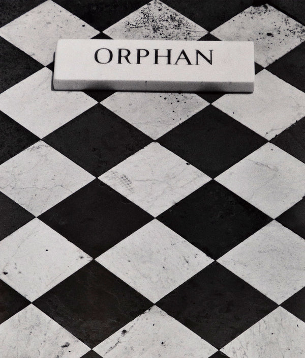 Sophie Callie "Orphan" Gelatin silver print, 1994. "Orphan" is a poignant example of the artist's inquiry into death, loss, and departure. The photograph features a close crop of a black and white checkered tombstone with an inscription plaque that reads, 'Orphan.'     